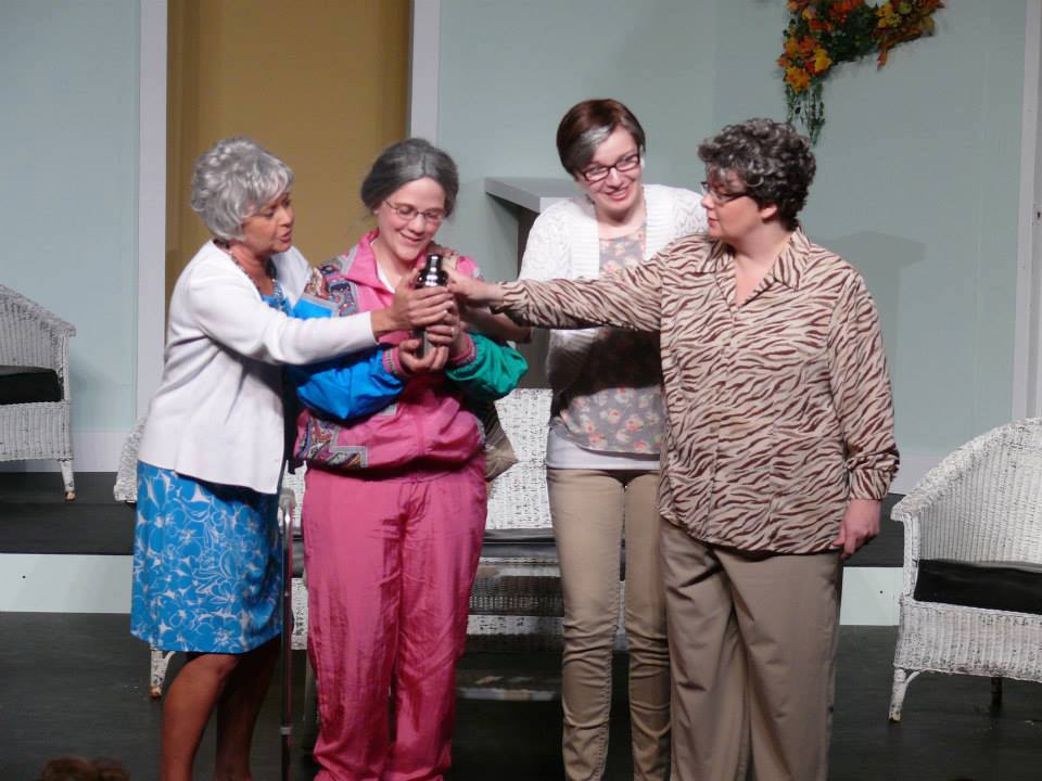 Four older women saying good bye to their friend's urn.